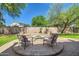 A brick firepit is nestled in a backyard patio surrounded by chairs and manicured landscaping at 6350 S Four Peaks Pl, Chandler, AZ 85249