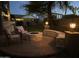 Twilight view of a brick patio with a firepit, outdoor seating, and landscape lighting at 6350 S Four Peaks Pl, Chandler, AZ 85249