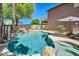 Inviting backyard pool area featuring a rock waterfall and mature palm trees at 6350 S Four Peaks Pl, Chandler, AZ 85249