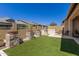 Landscaped backyard featuring artificial grass, stone accents, and a built-in grill, perfect for outdoor living at 6912 E Quill St, Mesa, AZ 85207