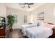 Bright bedroom featuring hardwood floors, ceiling fan, and windows with plantation shutters at 6912 E Quill St, Mesa, AZ 85207