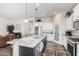 Bright kitchen featuring a granite island with barstool seating, white cabinetry, and stainless steel appliances at 6912 E Quill St, Mesa, AZ 85207
