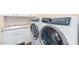 Modern laundry room includes white cabinets and updated washer and dryer at 6912 E Quill St, Mesa, AZ 85207
