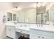 Main bathroom featuring double sinks, a vanity area, modern lighting, and an expansive mirror at 6912 E Quill St, Mesa, AZ 85207