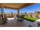 Inviting covered patio with outdoor seating and artificial turf for low-maintenance relaxation at 6912 E Quill St, Mesa, AZ 85207