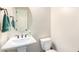 Bright powder room featuring a pedestal sink, decorative mirror, and a modern toilet at 6912 E Quill St, Mesa, AZ 85207