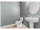 Modern half bathroom with gray walls, pedestal sink, and tile flooring at 7090 S 252 Dr, Buckeye, AZ 85326