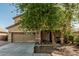 Attractive home featuring a two-car garage, covered entry, and desert-friendly landscaping at 7090 S 252 Dr, Buckeye, AZ 85326