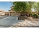 Beautiful home exterior showcasing a two-car garage, long driveway, and covered porch at 7090 S 252 Dr, Buckeye, AZ 85326