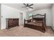 Cozy bedroom with a decorative wrought iron bed, carpet flooring, and ample natural light at 7090 S 252 Dr, Buckeye, AZ 85326