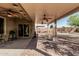 A covered patio area with a brick surface, multiple ceiling fans, and backyard views at 7090 S 252 Dr, Buckeye, AZ 85326