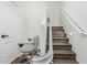 Well-lit staircase featuring hardwood steps, white railings, and a convenient stair lift at 7090 S 252 Dr, Buckeye, AZ 85326