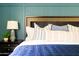 A blue-themed bedroom with a decorative headboard, side table, and a lamp at 7350 N Via Paseo Del Sur -- # P105, Scottsdale, AZ 85258