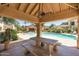 View from community gazebo with table and seating looking out to community pool with chairs and umbrellas at 7575 E Indian Bend Rd # 1137, Scottsdale, AZ 85250