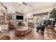 Spacious living room features a ceiling fan, stone fireplace and hearth, and comfortable leather seating at 7608 W Mescal St, Peoria, AZ 85345