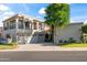 Beautiful two-story home featuring a three-car garage and a well-manicured front yard with a large tree at 8429 E Del Camino Dr, Scottsdale, AZ 85258