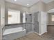 Bathroom featuring a soaking tub, glass-enclosed shower, and window providing natural light at 8854 W Augusta Ave, Glendale, AZ 85305