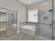 Luxurious bathroom featuring a soaking tub, glass-enclosed shower, and a spacious walk-in closet at 8854 W Augusta Ave, Glendale, AZ 85305