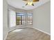 Bedroom with tile flooring, ceiling fan, and large windows with white blinds and shutters at 8854 W Augusta Ave, Glendale, AZ 85305