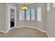 Cozy dining area with tile flooring, natural light from the windows, and a stylish chandelier at 8854 W Augusta Ave, Glendale, AZ 85305