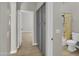 Hallway with storage cabinet and entry to a full bathroom with shower/tub combo and new toilet at 8854 W Augusta Ave, Glendale, AZ 85305