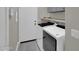 A modern laundry room featuring a front-loading washer and dryer and storage shelves at 8854 W Augusta Ave, Glendale, AZ 85305