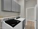 Laundry room with upper cabinets and shelf above the modern front-loading washer and dryer at 8854 W Augusta Ave, Glendale, AZ 85305
