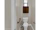 Cozy powder room with toilet, wall cabinet and window at 8854 W Augusta Ave, Glendale, AZ 85305