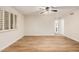 A large living room with neutral walls, vinyl floors, a ceiling fan and a window with wooden shutters at 917 N Blackbird Dr, Gilbert, AZ 85234