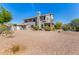 Home's spacious backyard with gravel ground cover, mature landscaping, and a partial view of the house exterior at 9203 E Topeka Dr, Scottsdale, AZ 85255