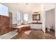 Well-lit bathroom with a glass door shower, soaking tub, and marble countertops at 9203 E Topeka Dr, Scottsdale, AZ 85255
