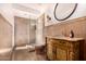 Elegant bathroom featuring glass shower, custom vanity, and decorative mirror at 9203 E Topeka Dr, Scottsdale, AZ 85255