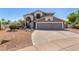 Two-story home displaying a spacious driveway and well-manicured desert landscaping at 9203 E Topeka Dr, Scottsdale, AZ 85255