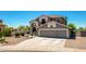 Charming two-story home boasts a three-car garage, desert landscaping, and tile roof at 9203 E Topeka Dr, Scottsdale, AZ 85255