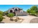 Charming two-story home boasts a three-car garage, desert landscaping, and tile roof at 9203 E Topeka Dr, Scottsdale, AZ 85255