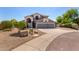 Charming home with desert landscaping, a spacious driveway, and a three-car garage, creating a welcoming front exterior at 9203 E Topeka Dr, Scottsdale, AZ 85255
