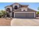 Two-story home with a gray exterior, a tiled roof, and a three-car garage showcasing its attractive curb appeal at 9203 E Topeka Dr, Scottsdale, AZ 85255