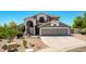 Beautiful home exterior with a three-car garage, manicured landscaping, and a stylish desert-friendly front yard at 9203 E Topeka Dr, Scottsdale, AZ 85255