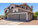 Two-story home showcasing a three-car garage and desert landscaping at 9203 E Topeka Dr, Scottsdale, AZ 85255