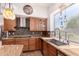 Bright kitchen featuring custom cabinetry, tiled backsplash, stainless steel appliances, and picture window at 9203 E Topeka Dr, Scottsdale, AZ 85255