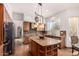 Open kitchen features a large island, stainless steel appliances, custom lighting and tiled backsplash at 9203 E Topeka Dr, Scottsdale, AZ 85255