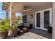 Inviting covered patio with a ceiling fan, cozy seating, a stylish stone pillar, and an ornate light fixture at 9203 E Topeka Dr, Scottsdale, AZ 85255