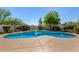 Freeform swimming pool with rock waterfall feature surrounded by desert landscaping and mature trees for a private backyard oasis at 9203 E Topeka Dr, Scottsdale, AZ 85255