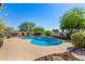 Sparkling pool surrounded by well-maintained landscaping, trees, and a stone patio, perfect for relaxation at 9203 E Topeka Dr, Scottsdale, AZ 85255
