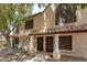 Two-story townhouse featuring a tile roof, covered entrance, and mature landscaping at 921 W University Dr # 1038, Mesa, AZ 85201