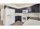 Well-lit kitchen with white appliances, dark cabinets, and a sink with ample counter space at 921 W University Dr # 1038, Mesa, AZ 85201
