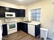 This kitchen showcases dark cabinets, white appliances, and wood-style flooring at 921 W University Dr # 1038, Mesa, AZ 85201
