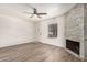 Bright living room featuring a fireplace, ceiling fan, wood floors, and neutral paint at 921 W University Dr # 1038, Mesa, AZ 85201