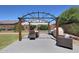 Landscaped backyard featuring a covered dining area, grill, and manicured lawn at 9750 E Radioactive Dr, Mesa, AZ 85212