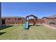 Backyard featuring a wooden playset with a slide and swings, ideal for outdoor fun at 9750 E Radioactive Dr, Mesa, AZ 85212